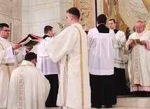 Podczas konsekracji dwaj diakoni trzymają rozłożoną księgę Ewangelii nad głową wyświęcanego hierarchy, a główny celebrans modli się nad nim.