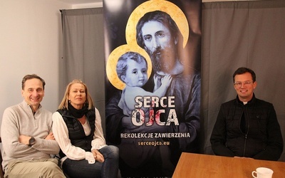 Od lewej: Marek i Adriana Zarembowie oraz ks. Mateusz Dudkiewicz przy rekolekcyjnym banerze, zapraszjącym na 27 dni z Sercem Ojca.