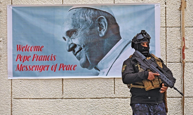 Plakat zapowiadający wizytę papieża, zawieszony na murze katedry w Bagdadzie.