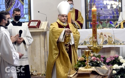 Bp Marek Mendyk okadzający trumnę zmarłego kapłana.