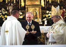 ▲	Prowincjał w obecności biskupa wręcza relikwiarze dr. Jerzemu Miszkiewiczowi, prezesowi stowarzyszenia.