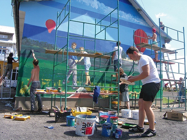 Tworzenie muralu na ścianie miejscowej szkoły przez Pracownię Malarstwa Ściennego i Witrażu z ASP w Gdańsku, prowadzoną przez prof. Jacka Zdybla.