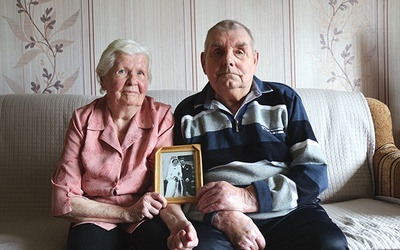 Anna i Józef Plochowie z fotografią ślubną wykonaną 65 lat temu.