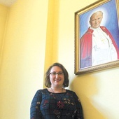 Dyrektor Dominika Warmuz przy portrecie patrona miejsca.