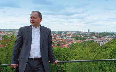 ▲	Ksiądz Wojciech Górlicki  na Górze Trzech Krzyży. W tle panorama miasta.