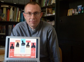 Ks. Mariusz Wilk z plakatem promującym projekt.