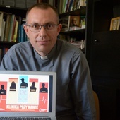 Ks. Mariusz Wilk z plakatem promującym projekt.