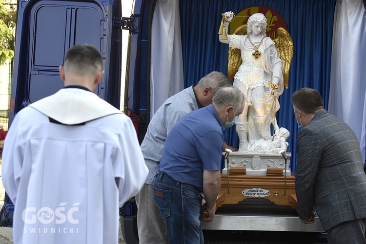 Przedstawiciele parafian wyjmujący figurę św. Michała Archanioła z ruchomej kaplicy.