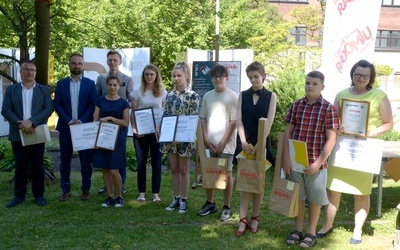 Laureaci z organizatorami i wręczającymi nagrody w ogrodzie Miejskiej Biblioteki Publicznej w Radomiu.