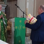 Wieloletni proboszcz pionkowskiej parafii odbiera podziękowanie od reprezentantów wspólnoty.