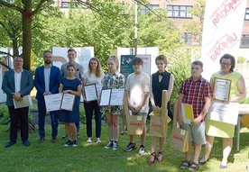 Zwycięzcy, organizatorzy i wręczający nagrody w ogrodzie Miejskiej Biblioteki w Radomiu.
