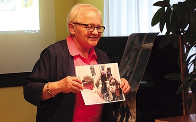 ◄	Danuta Szczepańska pokazuje zdjęcia dokumentujące udzielanie pomocy żywnościowej.