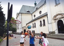 ▲	Dzieci próbują trafić piłką do kosza w ramach jednego z konkursów sportowych.