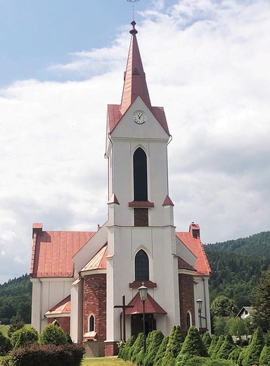 ►	Kościelna wieża na tle Beskidów.