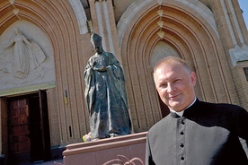 Ksiądz Marcin Rogala przy pomniku Prymasa Tysiąclecia, który stoi przed radomską katedrą.