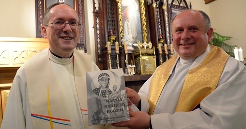 Ks. Albert Warso (z lewej) i ks. Mirosław Kszczot z książką wyznaczającą tegoroczny rytm pielgrzymowania.