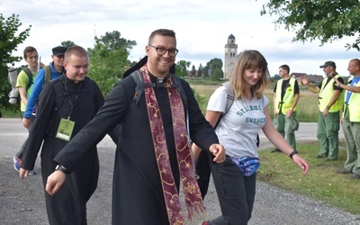 Uśmiechnięci pielgrzymi dochodzący do postoju.