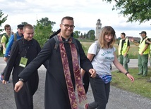 Uśmiechnięci pielgrzymi dochodzący do postoju.