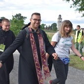 Uśmiechnięci pielgrzymi dochodzący do postoju.