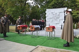 ▲	Trumny bohaterów przed granitową ścianą z wizerunkiem przedwojennego orła wojskowego.