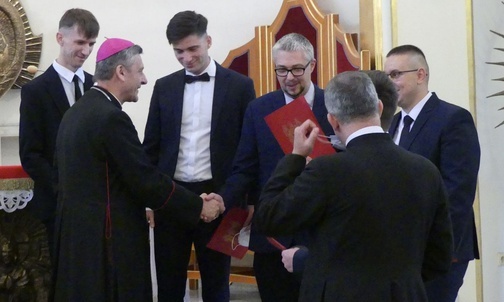 Alumni z bp. Romanem Pindlem w kaplicy kurialnej.