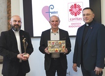 ▲	Ks. Damian Drabikowski, dyrektor Caritas Diecezji Radomskiej, ze statuetką Viventi Caritate. Obok Zbigniew Miazga i ks. Karol Piłat, zastępca dyrektora CDR.
