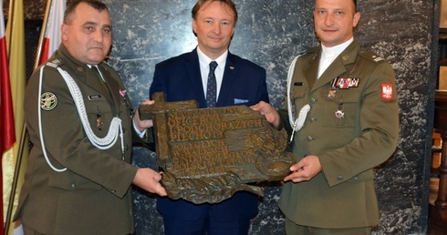 Od lewej stoją: płk Leszek Iwaniec, Paweł Dycht i ks. mjr Łukasz Hubacz.