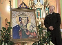 Ks. Stanisław Śliwa pokazuje obraz MB Bocheńskiej, jubileuszowy dar róż różańcowych.