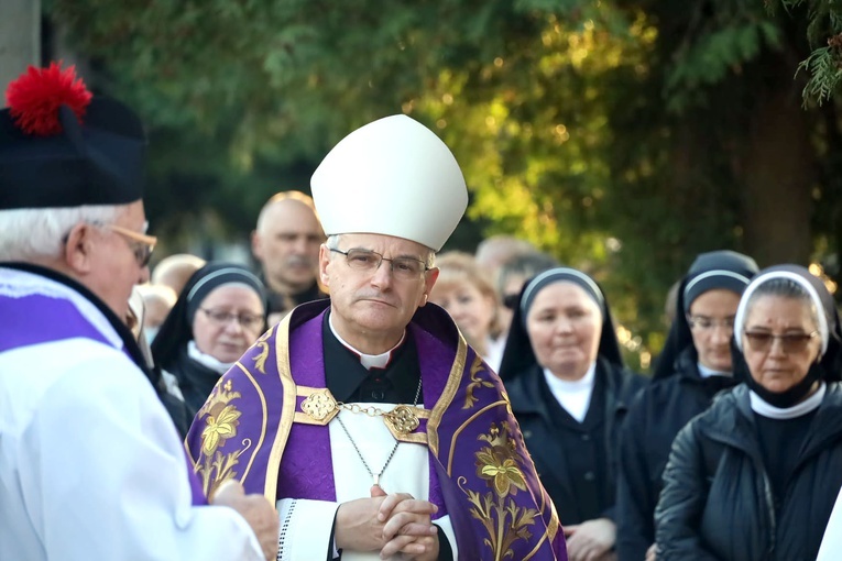 Biskup w czasie procesji z modlitwą różańcową między grobami.