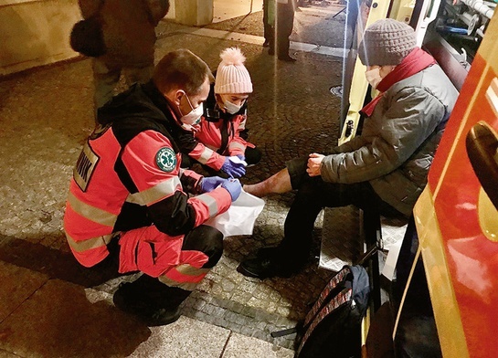 Osoby bezdomne z Białegostoku mogą liczyć na profesjonalną pomoc medyczną. Ks. Andrzej opatruje pacjentkę.