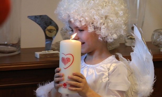 Świeca na wigilijnym stole wspiera dzieci w potrzebie.