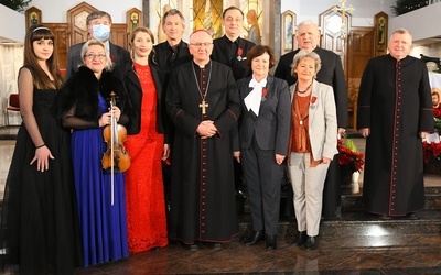 Odznaczony Robert Grudzień stoi w drugim rzędzie trzeci od prawej. W środku abp Stanisław Budzik.