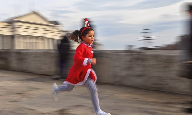 Dziewczynka w świątecznym stroju biegnie przez kamienny most w Skopje.
26.12.2021   Macedonia Północna