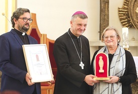 	Lidia Greń-Wajdzik odbiera nagrodę z rąk bp. Romana Pindla i ks. Piotra Hoffmanna.