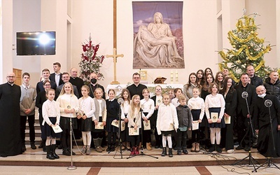 Schola i zespół z bp. Markiem Solarczykiem i duszpasterzami.