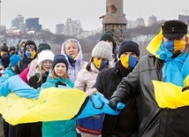 22 stycznia 2022 r. Mieszkańcy Kijowa z ogromną flagą swojego kraju stoją na moście  na rzece Dniepr.  W ten sposób świętują 103. rocznicę zjednoczenia zachodniej i wschodniej Ukrainy w 1919 roku.