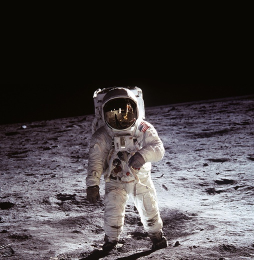 Edwin „Buzz” Aldrin, pilot lądownika Eagle, na powierzchni Księżyca. Zdjęcie wykonał Neil Armstrong, dowódca misji Apollo 11 (na wizjerze hełmu Aldrina widać odbicia fotografa, flagi Stanów Zjednoczonych wbitej w księżycowy grunt  oraz lądownika).