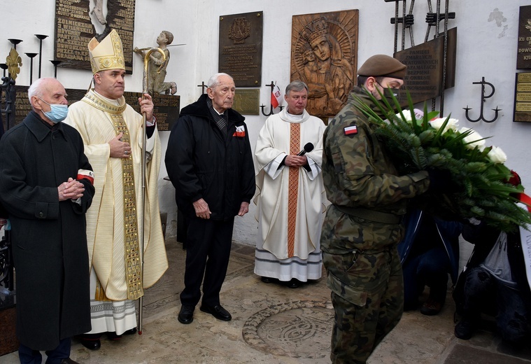 Po Mszy św. biskup wraz z (od lewej): prof. Jerzym Grzywaczem oraz kmdr. Romanem Rakowskim złożyli kwiaty przy nowo odsłoniętej i poświęconej tablicy ku czci poległych i zmarłych żołnierzy wszystkich formacji Armii Krajowej.