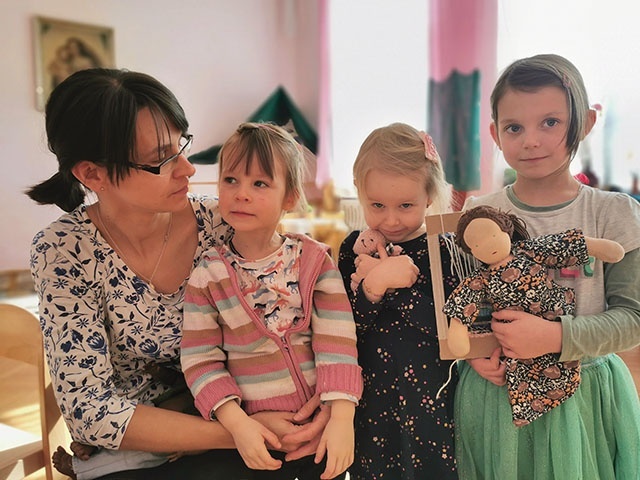 	Magdalena Garstka z Dorotką (z lewej), Gabrysią i Antosią (w środku) ściskającą różowego misia.