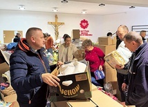 Ks. Robert Kurpios z wolontariuszami przygotowuje kolejne transporty darów.