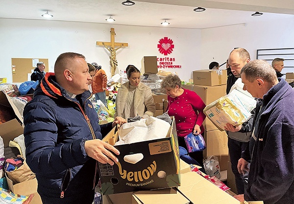 Ks. Robert Kurpios z wolontariuszami przygotowuje kolejne transporty darów.