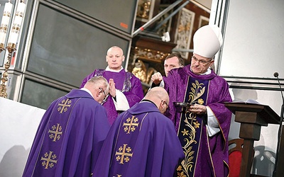 ▲	Biskup posypuje głowy popiołem koncelebrującym kapłanom: ks. Piotrowi Śliwce i ks. Dominikowi Ostrowskiemu.