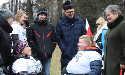 Prezes Jadwiga Klimonda i ks. Krzysztof Ciurla z biegaczami na wózkach: Magdaleną Wójcik i Sebastianem Balasem.