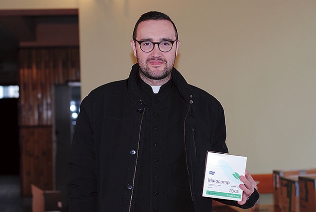 Ksiądz Łukasz Dymora pokazuje lekarstwa, na które ludzie czekają w objętym wojną kraju.