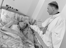 Bp Adam Bałabuch namaszczający przebywajacego w hospicjum kapłana.