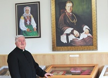 Ksiądz Stanisław Morawa zaprasza do zwiedzania sali muzealnej.