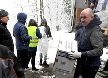 Ks. Andrzej Majka z grupą kleryków rozładowujących transport darów z Włoch.