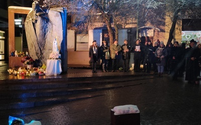 Uczestnicy modlitwy przed figurą św. Jana Pawła II.