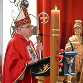 Biskup w czasie głoszenia homilii w kościele parafialnym. W tle rzeźba patrona strażaków.