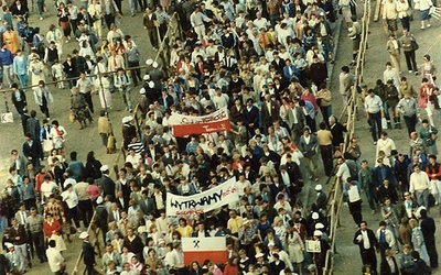 	12 czerwca 1987 r. Trwa pokojowa demonstracja na ulicach Gdańska, zorganizowana po papieskiej Mszy św. na Zaspie. Na fotografii widać tłum ludzi z prosolidarnościowymi flagami i transparentami.